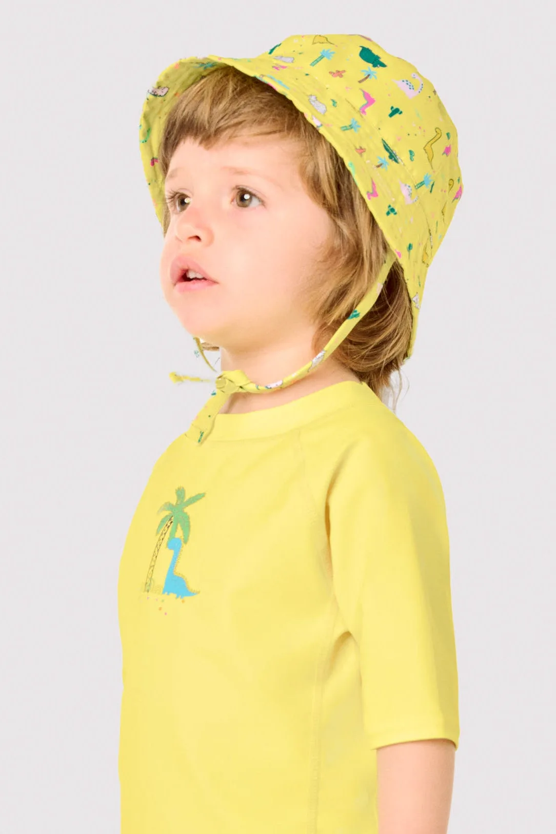 Gorro de playa bebé ala recta estampado dinosaurios amarillo
