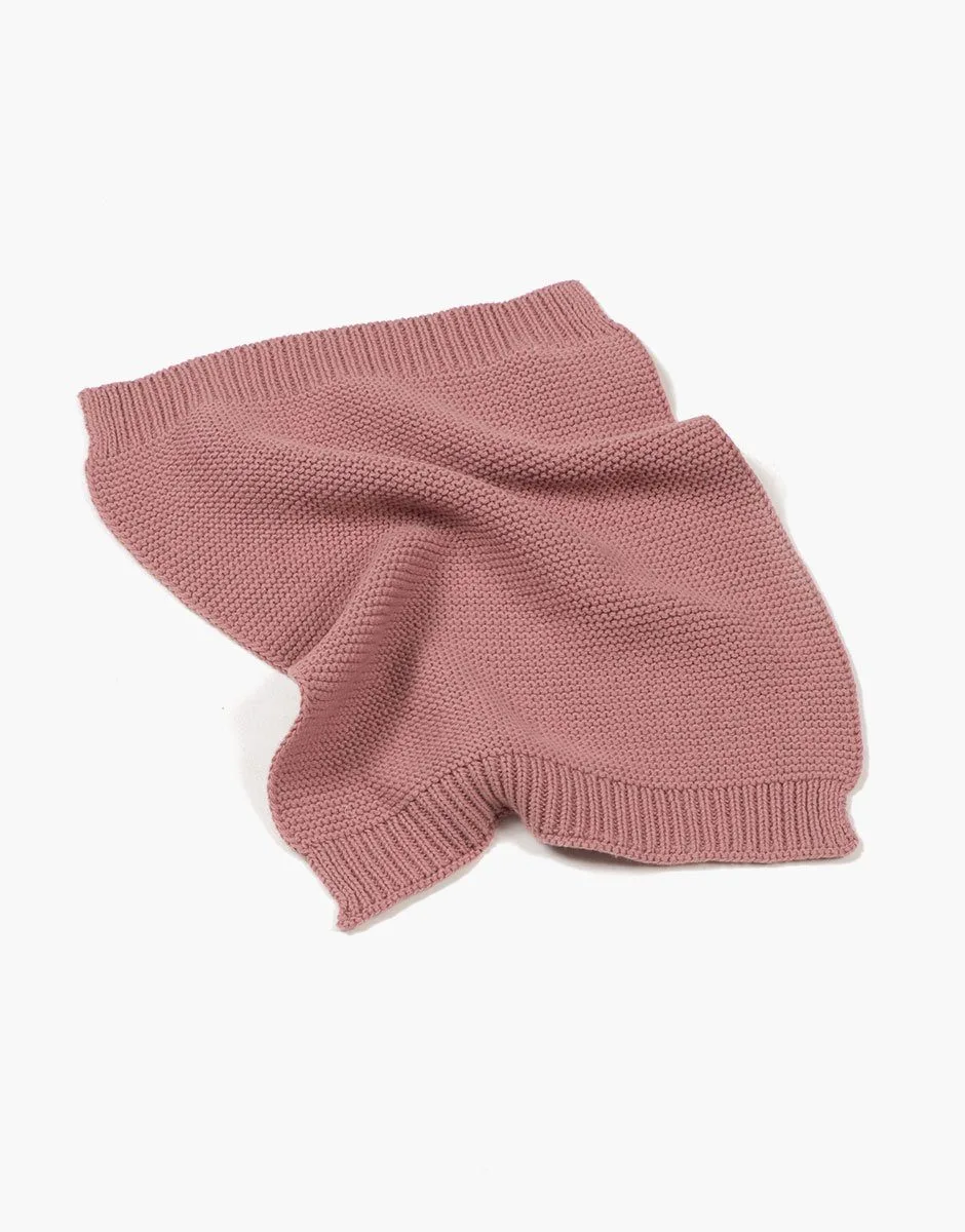 Elegir una manta de punto color rubor para la cama de tu muñeca