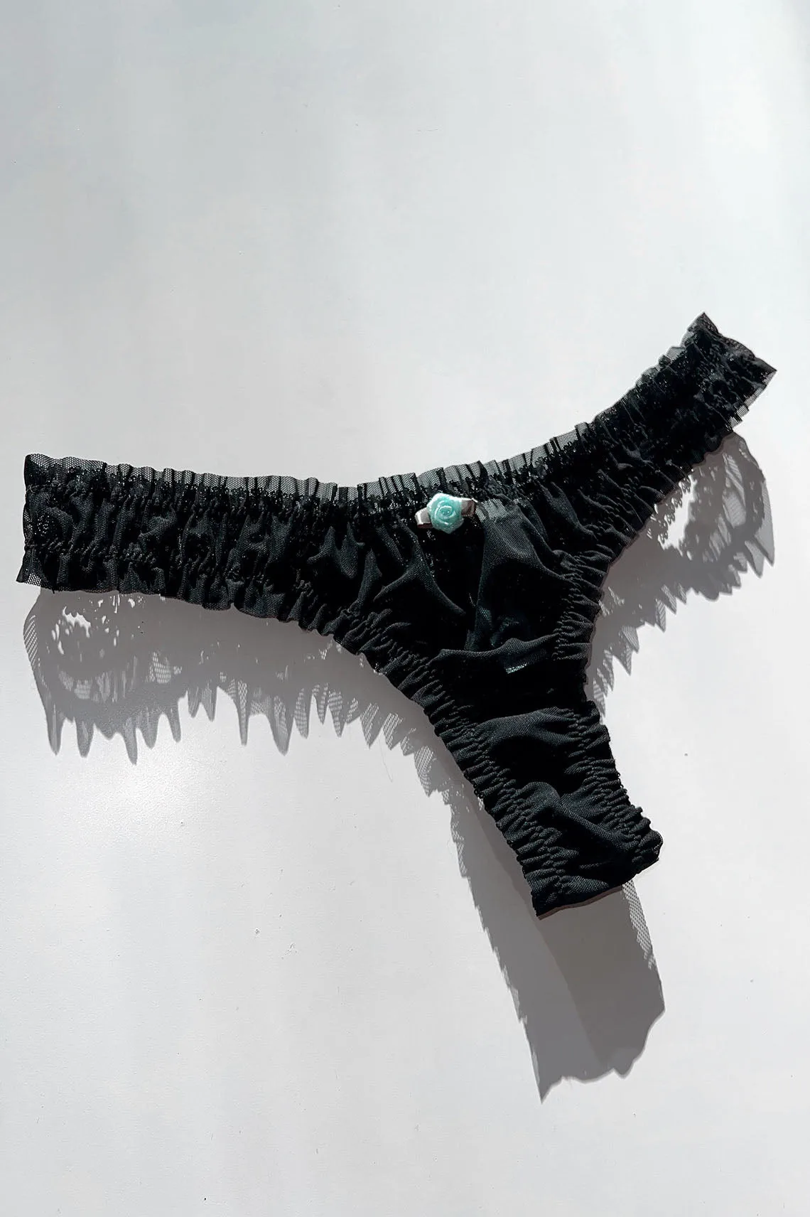 Tanga negro de malla reciclada con rosetón de adelfa